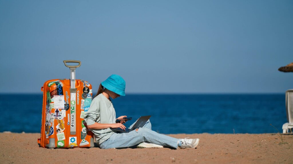 海辺でパソコンを使っている女性
